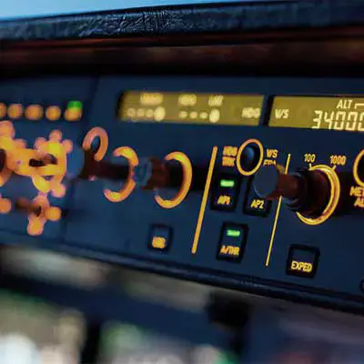 Aircraft cockpit instruments dashboard at night.